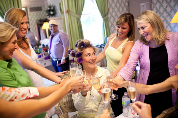 the bride in hair rollers and her bridesmaids toasting champagne as they get ready - photo by Washington DC wedding photojournalist Paul Morse